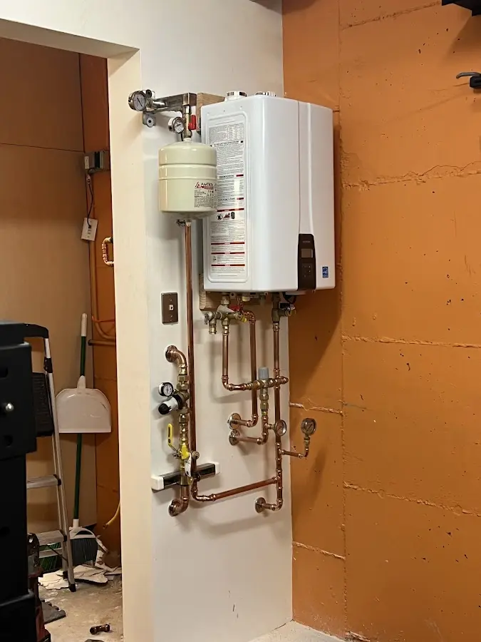 Plumbing technician inspecting water heater connections in Abilene